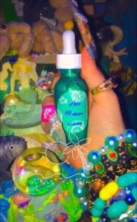 a person holding a bottle of mermaid oil
