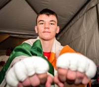 a young man in an irish flag holding his fists
