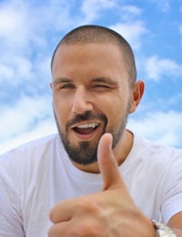 a man with a beard giving a thumbs up