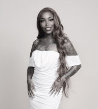 a woman in a white dress with tattoos posing