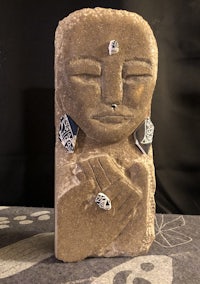 a stone sculpture with a face on it