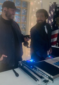 two men standing in front of a dj booth