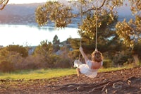 a woman is swinging on a tree swing