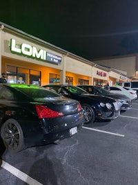 a group of cars parked in front of a store at night