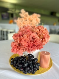 a table with flowers and grapes on it