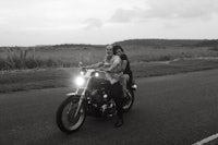 a black and white photo of two people on a motorcycle