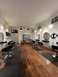 a hair salon with a wooden floor and chairs