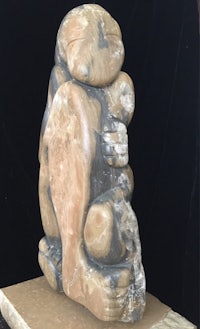 a stone sculpture of a monkey sitting on top of a block