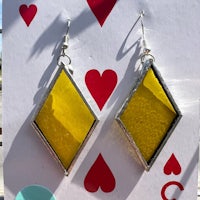 a pair of yellow diamond earrings on a card deck