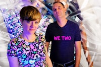 two people posing in front of a colorful background