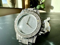 a watch with diamonds on it sitting on a table