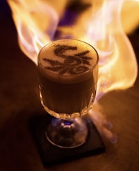 a cup of coffee with flames on top of it