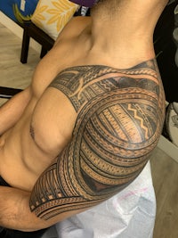 a man with a tribal tattoo on his shoulder