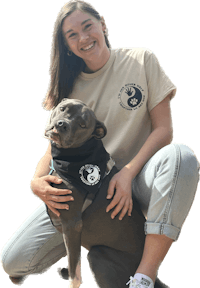 a woman posing with a dog wearing a t - shirt
