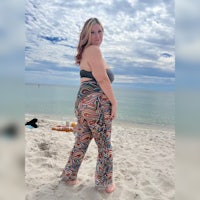 a woman in a bikini standing on the beach