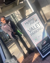 a woman standing next to a sign that says valet parking