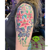 a woman with a colorful lily tattoo on her arm