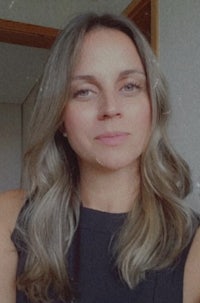 a woman wearing a black top and gray hair