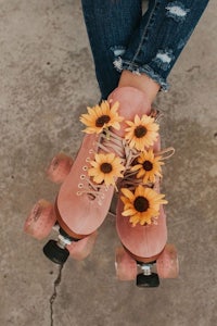 a pair of pink roller skates with sunflowers on them