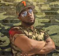 a man wearing sunglasses and a camouflage hat