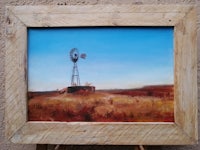 a painting of a windmill in a wooden frame
