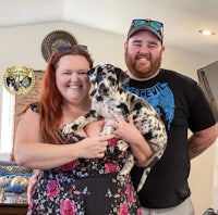 a man and woman holding a dalmatian puppy