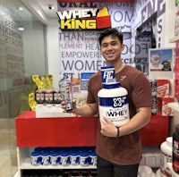 a man standing in front of a whey king store