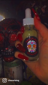 a person holding a bottle of cbd with a skull on it