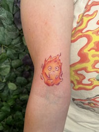 a person with a tattoo of a fireball on their arm