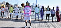a group of people standing on a boardwalk with colorful t - shirts