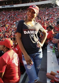 a woman in a red t - shirt standing in a stadium