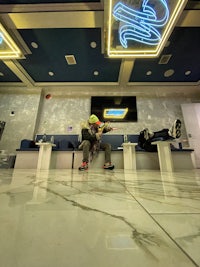 a skateboarder in a lobby with a neon sign