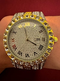 a gold and diamond watch on a person's wrist