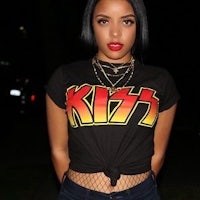 a woman wearing a black t - shirt with the word kiss on it