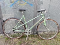 a green bicycle leaning against a fence