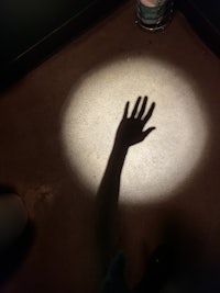 the shadow of a person's hand on the floor