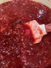 a pot of red sauce with a spoon in it