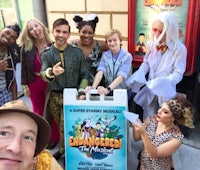 a group of people posing in front of a poster for enchanted the musical