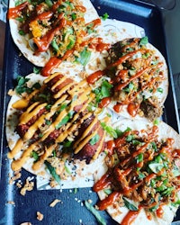 four tacos on a tray
