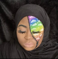 a woman wearing a hijab with a rainbow painted on her face