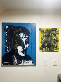 two paintings hanging on a wall in a room