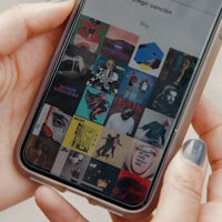 a person holding a phone with a picture of music on it
