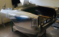 a silver car is being worked on in a garage