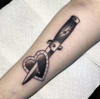 a tattoo of a knife with a heart in it