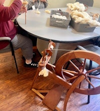 a group of people sitting around a table with a spinning wheel