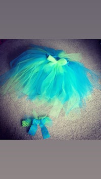 a blue and green tutu with a bow on the floor