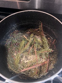 a frying pan with pine needles in it