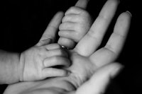 a black and white photo of a baby's hand