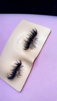 a pair of false eyelashes on a purple surface