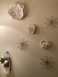 a bathroom with flowers and towels on the wall